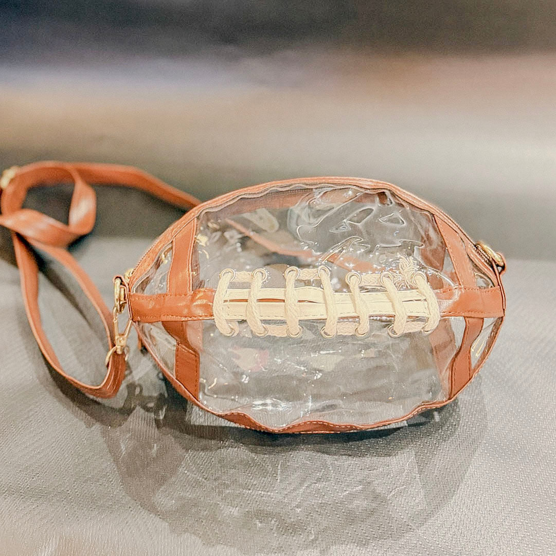 Clear football game day purse with brown trim, white lacing and shoulder strap