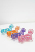 Four glitter squishy wiener dogs in pink, orange, purple, and blue