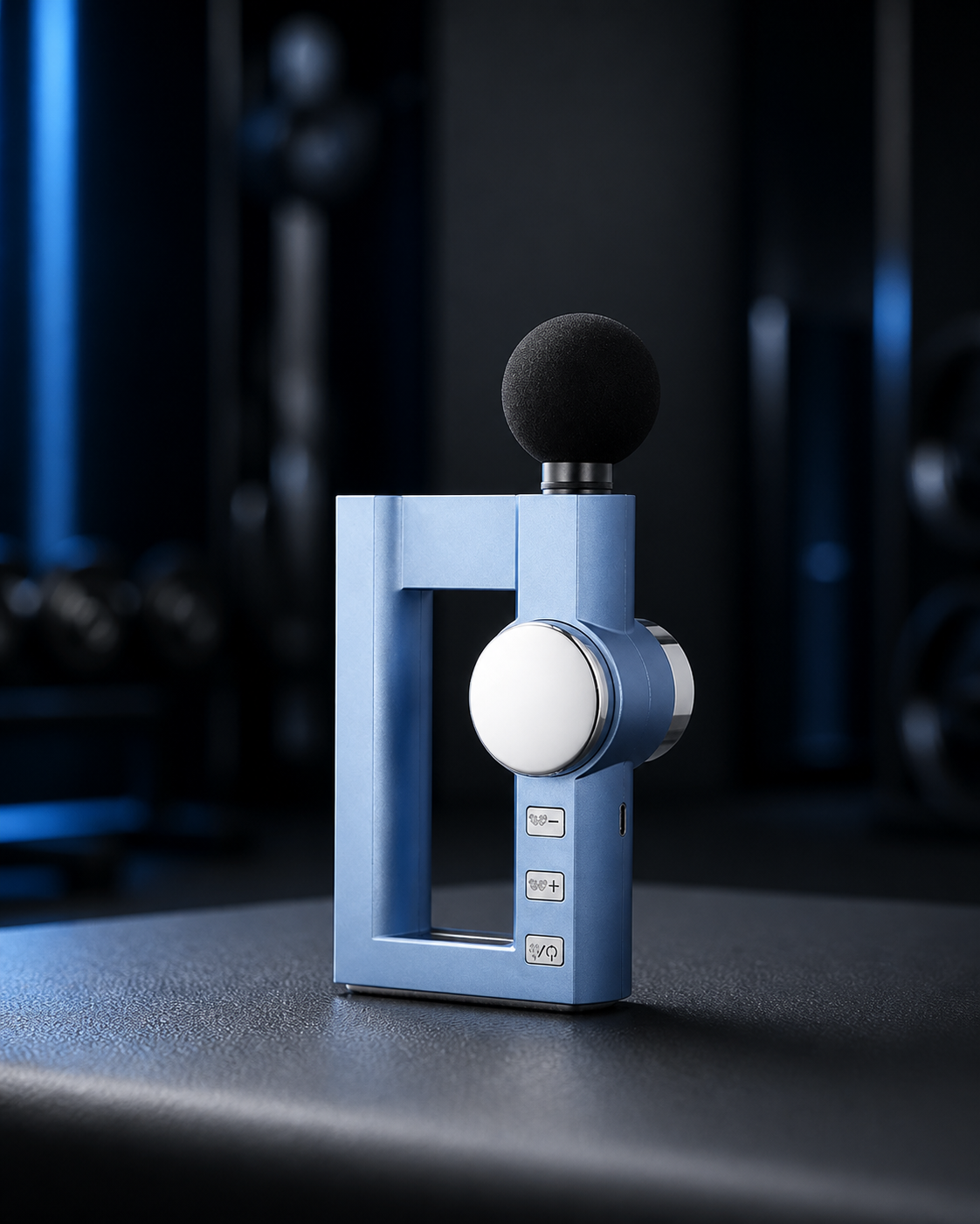 Compact blue mini massage gun in a dark athletic recovery setting