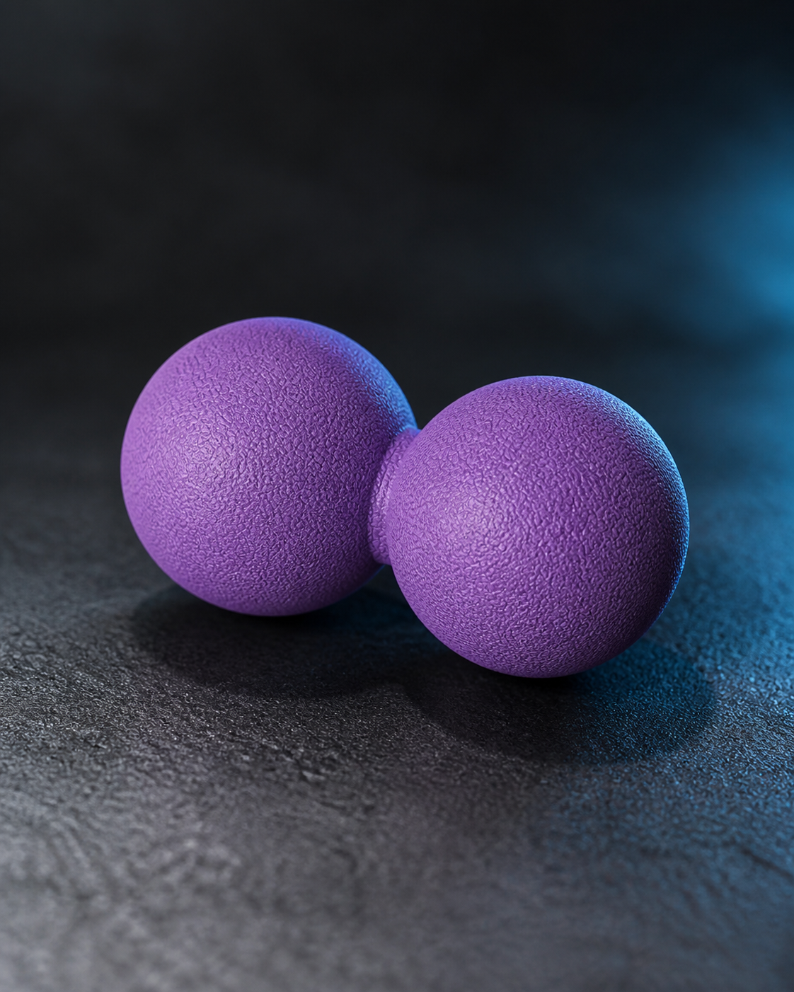 Purple peanut massage ball on a dark athletic recovery surface